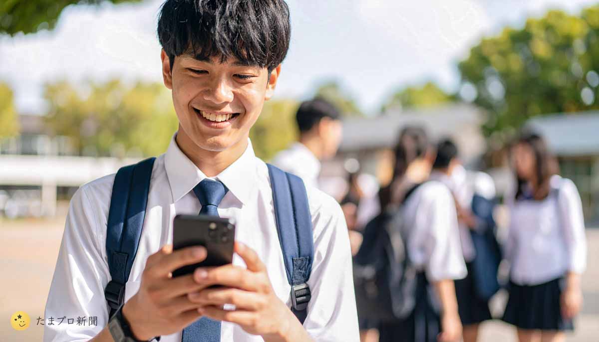 男子生徒が校庭でsnsをしている