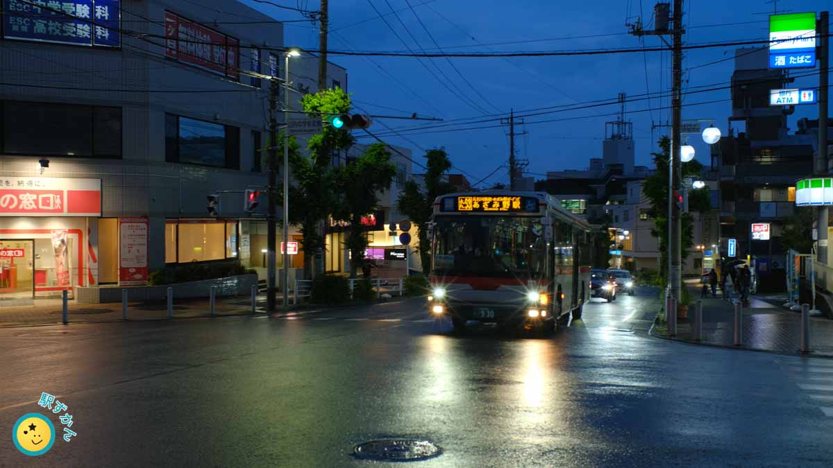 雨の夕暮れのバス通り