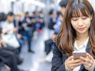 電車内でスマホアプリを見る人たち