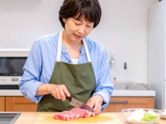 母親が台所で肉をカット