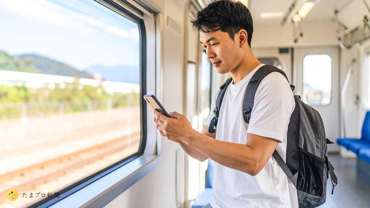 電車内でスマホを使う男性