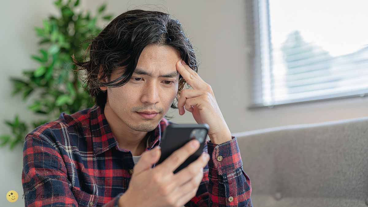 スマホ画面をチェックする男性
