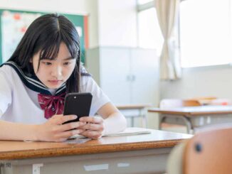 iPhoneをチェックする女子高生