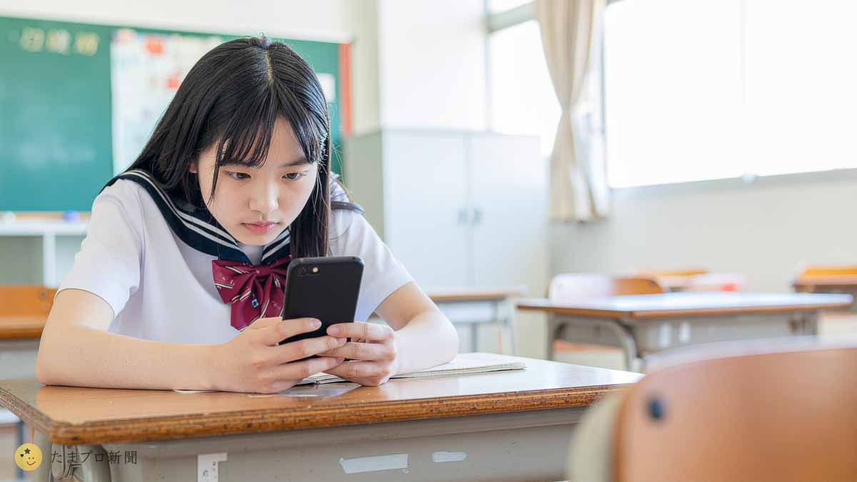 iPhoneをチェックする女子高生