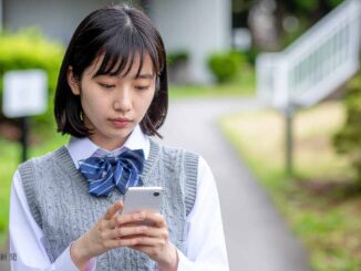 スマホを見て悩む女子高生