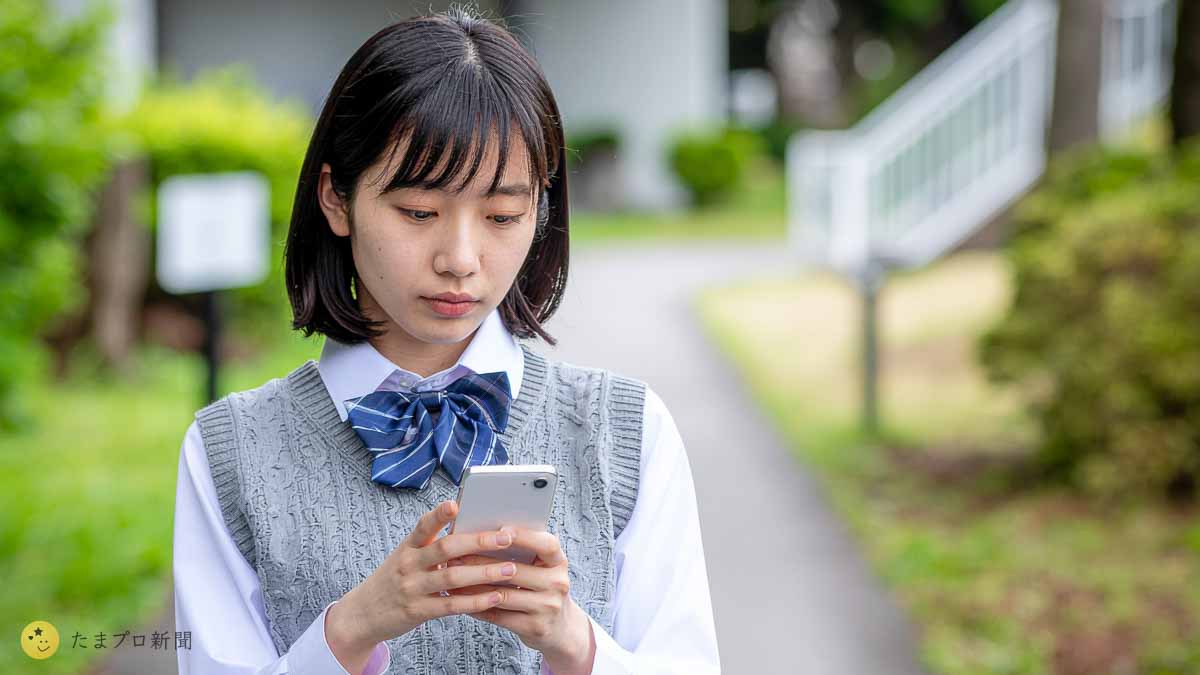 スマホを見て悩む女子高生