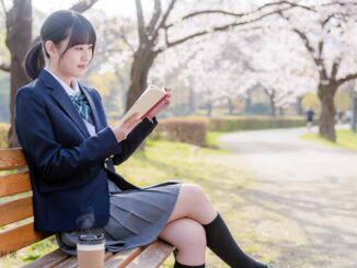 満開の桜の下で読書する女子高校生